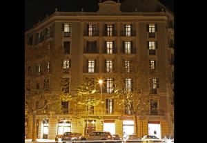 a large building with cars parked in front of it at MH Apartments Suites in Barcelona