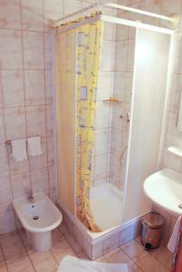 een badkamer met een douche, een toilet en een wastafel bij Guest House Arvaj in Kranj