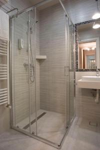 a shower with a glass door in a bathroom at Homorod Hotel in Băile Homorod