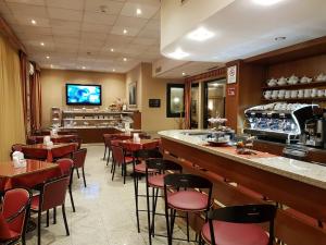 a restaurant with a bar and some tables and chairs at Hotel Tirreno in Genoa