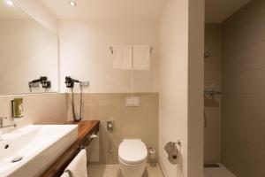 a bathroom with a white toilet and a sink at Heikotel - Hotel Am Stadtpark in Hamburg