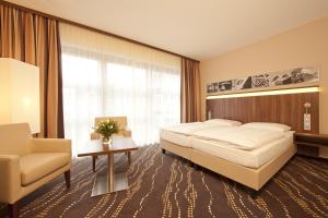 a hotel room with a large bed and a large window at Heikotel - Hotel Am Stadtpark in Hamburg