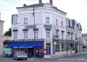 duży biały budynek na rogu ulicy w obiekcie Hotel de la gare w mieście Cosne-Cours-sur-Loire