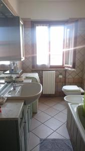 uma casa de banho com um lavatório, um WC e uma janela. em IEO - HUMANITAS - MILANO CENTRO a 15 minuti em Locate di Triulzi