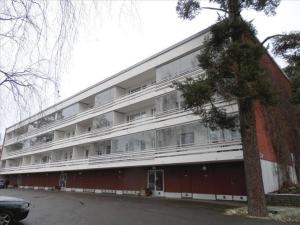 a large red and white building with a tree at Savonlinna Holidays apartments in Savonlinna