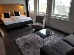 Habitación con cama, silla y sofá en 201 Hotel, en Reikiavik