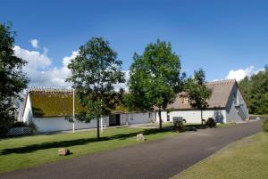 a house on a street with trees in the foreground at Sankt Helene Holiday Center in Tisvildeleje