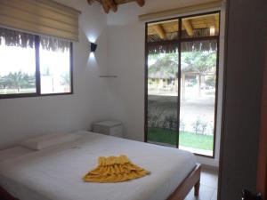 a bedroom with a bed and a large window at Hospedajes de Pato in Olón