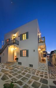een groot wit huis met een luchtachtergrond bij Galini Hotel in Mykonos-stad