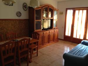 a living room with a dining table and a tv at Chalet turistico Riumar in Riumar