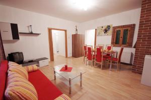 a living room with a red couch and a table at Raisa Apartments Fünkhgasse in Pressbaum