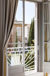 ein offenes Fenster mit Blick auf einen Balkon in der Unterkunft Maison Du Collectionneur in Aix-en-Provence