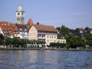 uma cidade com uma torre de relógio e um rio em Hotel Seegarten em Überlingen