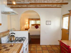 a kitchen with a stove and a bedroom with a bed at Briarwood Inn in Carmel