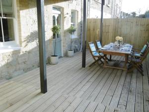 a wooden deck with a table and chairs on it at Little Grosvenor in Ventnor