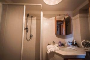 y baño con ducha, lavabo y espejo. en Villa Sarino, en Savoca