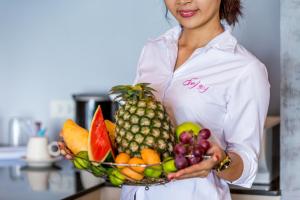 a woman is holding a bowl of fruit at Enjoy Beach in Bophut