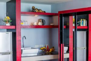 a kitchen with red shelves and a sink at Enjoy Beach in Bophut