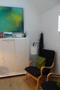 a living room with a chair and a painting on the wall at Natursti Silkeborg Bed & Breakfast in Them