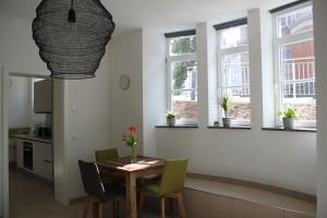 a dining room with a table and chairs and windows at Stadtvilla Würzburg in Würzburg