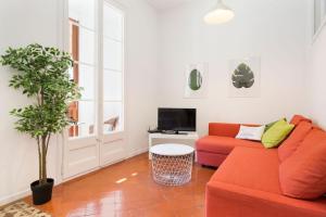 バルセロナにあるStay U-nique Apartments Granadosのリビングルーム(赤いソファ、テレビ付)
