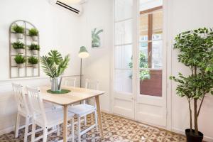 バルセロナにあるStay U-nique Apartments Granadosのダイニングルーム(テーブル、椅子、植物付)