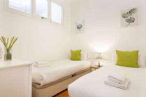 バルセロナにあるStay U-nique Apartments Granadosの白い部屋のベッド2台 緑の枕付