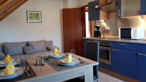 a living room with a table and a kitchen at Ferienwohnung Raithel in Schwarzenbach an der Saale