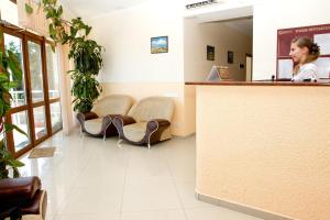 a woman sitting at a counter in a waiting room at Mileta Hotel in Feodosia