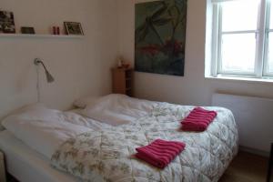 Un dormitorio con una cama con toallas rojas. en Natursti Silkeborg Bed & Breakfast en Them