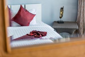 a bed with red pillows and a red bow on it at Enjoy Beach in Bophut