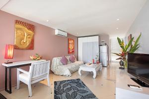 a living room with a couch and a tv at Enjoy Beach in Bophut