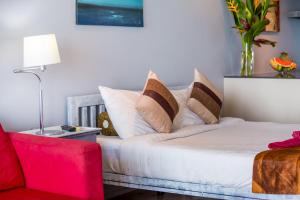 a bedroom with a white bed and a red chair at Enjoy Beach in Bophut