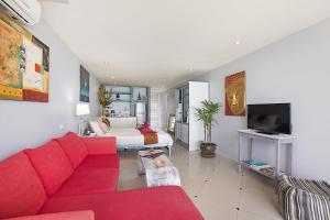 a living room with a red couch and a bed at Enjoy Beach in Bophut