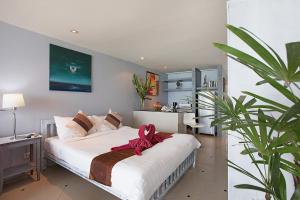 a bedroom with a large bed with a pink bow on it at Enjoy Beach in Bophut