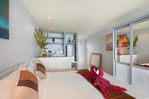 a bedroom with a large bed with a red ribbon on it at Enjoy Beach in Bophut
