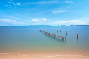 a pier in the water next to a beach at Enjoy Beach in Bophut