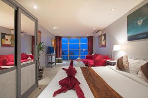 a bedroom with a large bed and a red couch at Enjoy Beach in Bophut