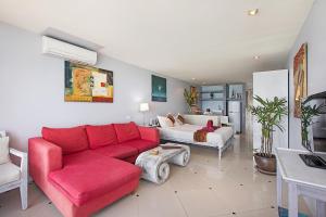 a living room with a red couch and a bedroom at Enjoy Beach in Bophut