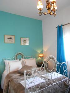 a bedroom with a bed with blue walls and a chandelier at King's House Douro Valley in Sedielos