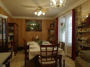 a dining room with a table and a ceiling fan at Ambassador B&B Guest Home in Stratford