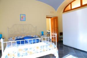 a bedroom with a white bed with blue pillows at Le terrazze di Cristina in Vietri