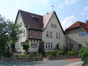 a large white building with a brown roof at Hotel Flower Power in Hehlen