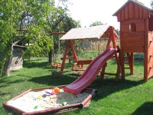 einen Spielplatz mit Rutsche und Spielstruktur in der Unterkunft Manó Vendégház in Pázmánd