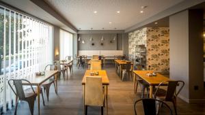 a restaurant with wooden tables and chairs and a large window at Apartahotel 5dos5 in Oviedo