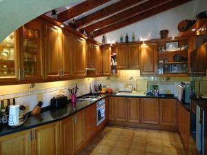 une cuisine avec des placards en bois et des comptoirs noirs dans l'établissement Casa Andalus Holiday Villa, à Jávea