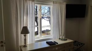 une fenêtre avec une table et une lampe devant elle dans l'établissement Hotell Grönfeltsgården, à Karlskoga