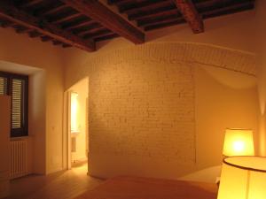 Cette chambre est dotée d'un mur en briques et d'une lampe. dans l'établissement Rinathos Guesthouse, à Arezzo