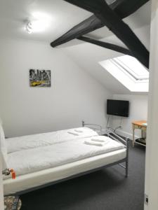 łóżko w pokoju z białymi ścianami w obiekcie Royal Guest House II w mieście Viersen