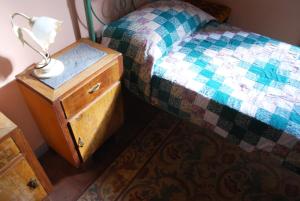 uma cama com uma mesa de cabeceira com um candeeiro em Casa Verdi - House of Travelers em Catânia